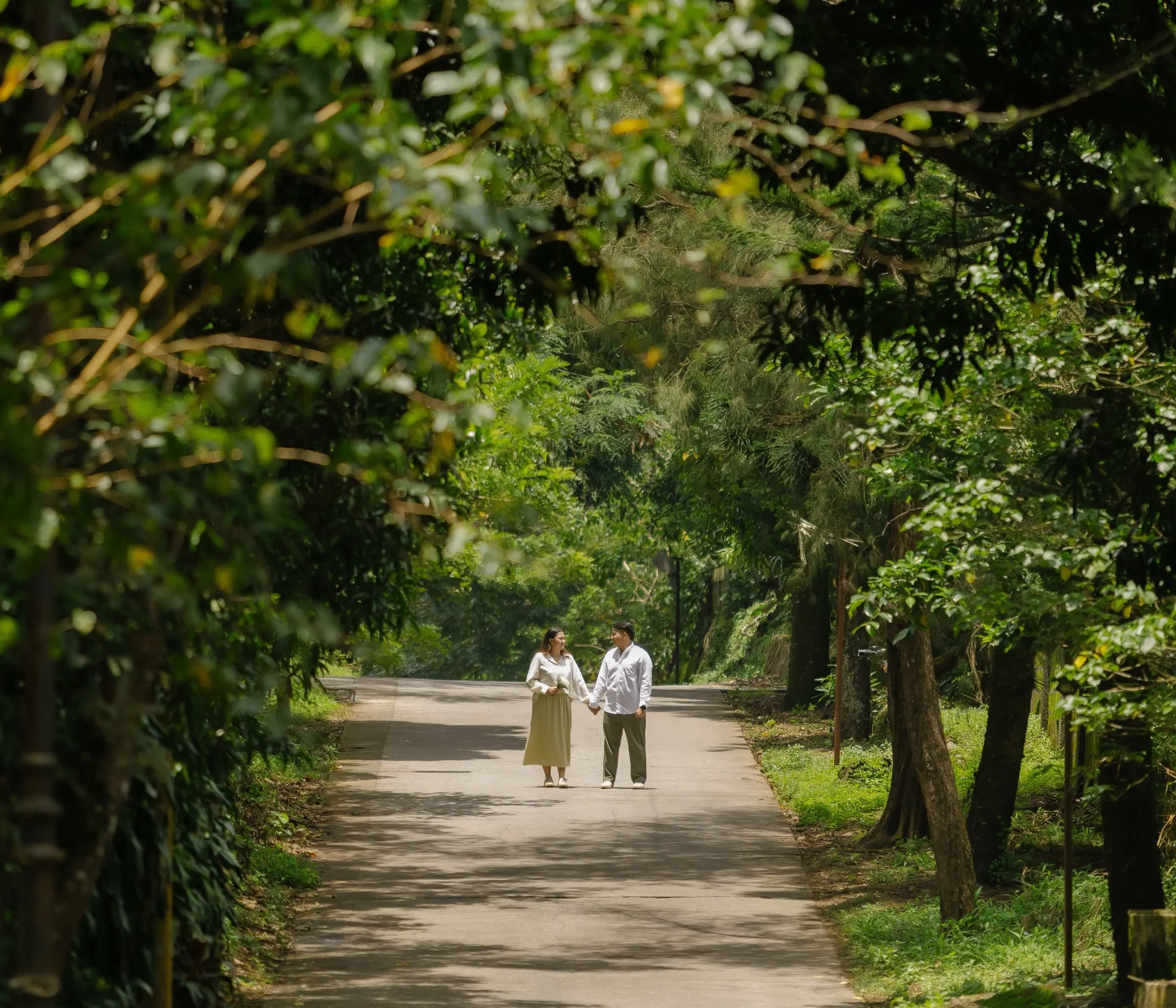 Carlvin and Samantha walking down a tree-lined road